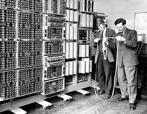 Peter Burden and Frank Hawley from Wolverhampton College of Technology examining a program tape from the computer in the 1960s