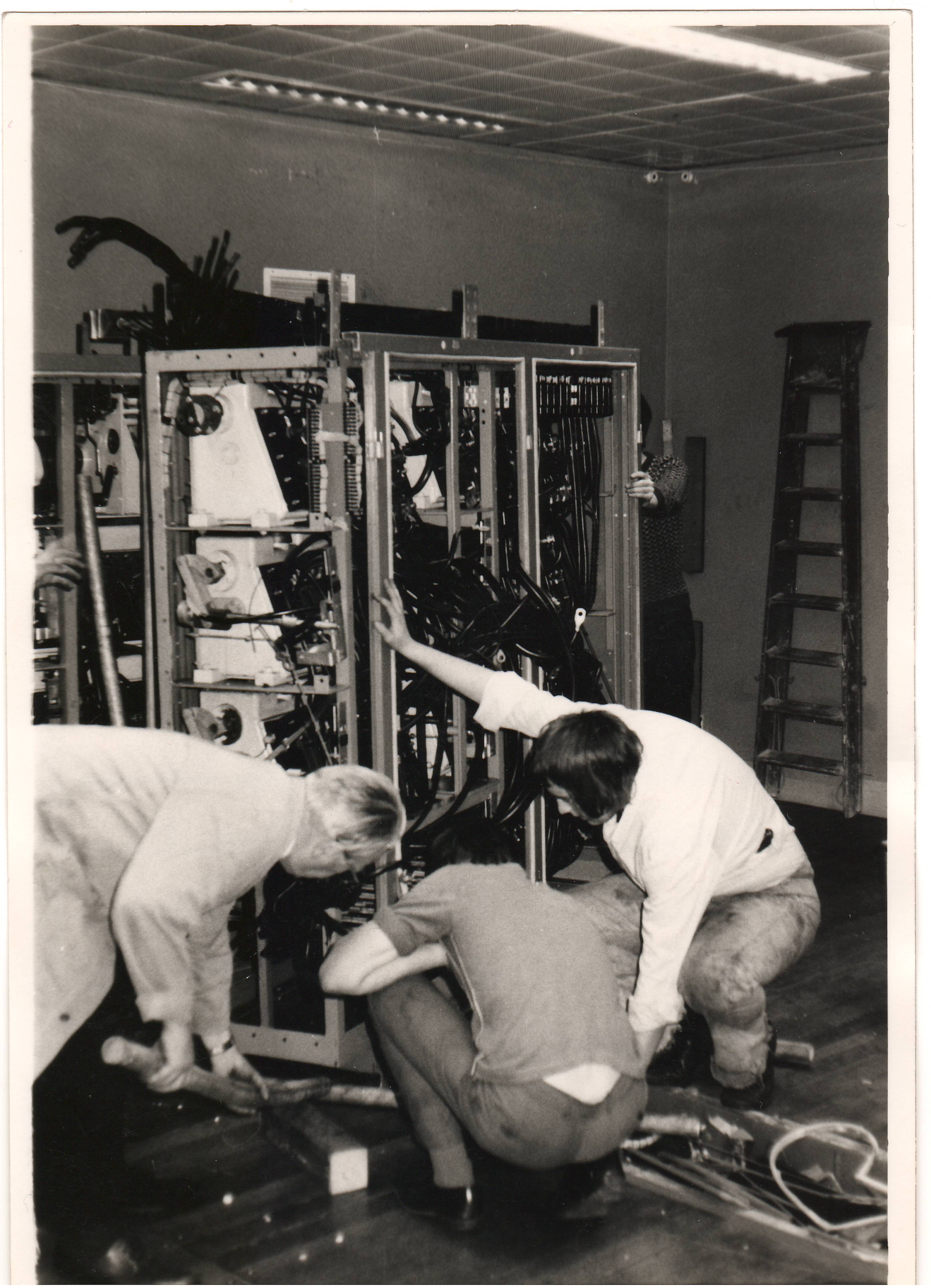 Fig 15: The downstairs room with its false floor, the computer finally removed and the engineers dismantling the cabling of which there was a considerable quantity. Large pieces of cabling had to be of a precise length so as not to upset the timing of the computer's operation. 