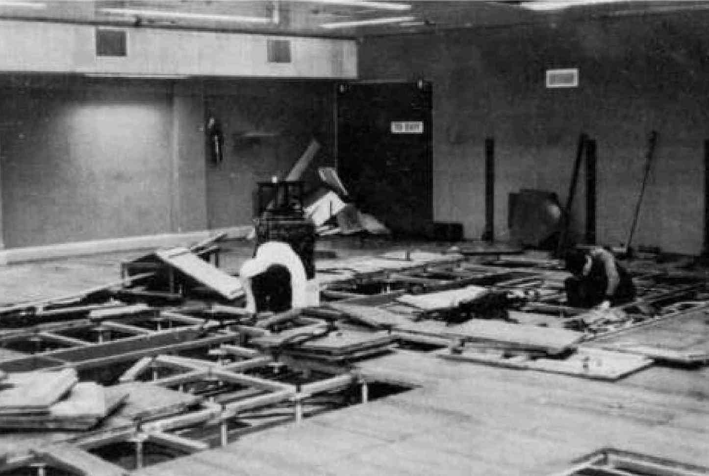 Fig 16: The downstairs room with its false floor, the computer finally removed and the engineers dismantling the cabling of which there was a considerable quantity. Large pieces of cabling had to be of a precise length so as not to upset the timing of the computer's operation. 